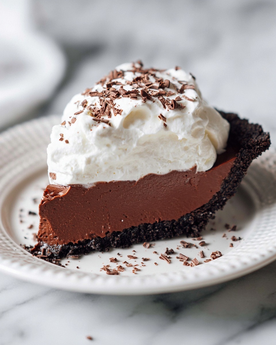 A close-up of a chocolate tart placed on a white plate, showing one large smooth top layer of rich dark brown chocolate filling with a silky texture, and a thick, darker crumbly crust made from crushed cookies surrounding the edges and base. The tart has one slice removed, revealing the smooth, firm inner texture of the chocolate filling and the contrast with the rough, crumbly crust. The background and surface have a white marbled texture. photo taken with an iphone --ar 4:5 --v 7