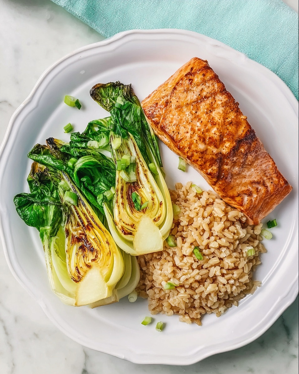 Sheet-Pan Salmon with Bok Choy & Miso Glaze Over Brown Rice Recipe 6 Large white serving platter featuring multiple portions of perfectly cooked grilled salmon fillets with a caramelized exterior, accompanied by generous servings of fluffy brown rice and vibrant grilled baby bok choy with char marks, all arranged neatly together to showcase the complete meal, photographed from a 3/4 angle on a white marble countertop with natural lighting, styled as a professional hero shot from a food magazine, photo taken with an iphone --ar 4:5 --v 7