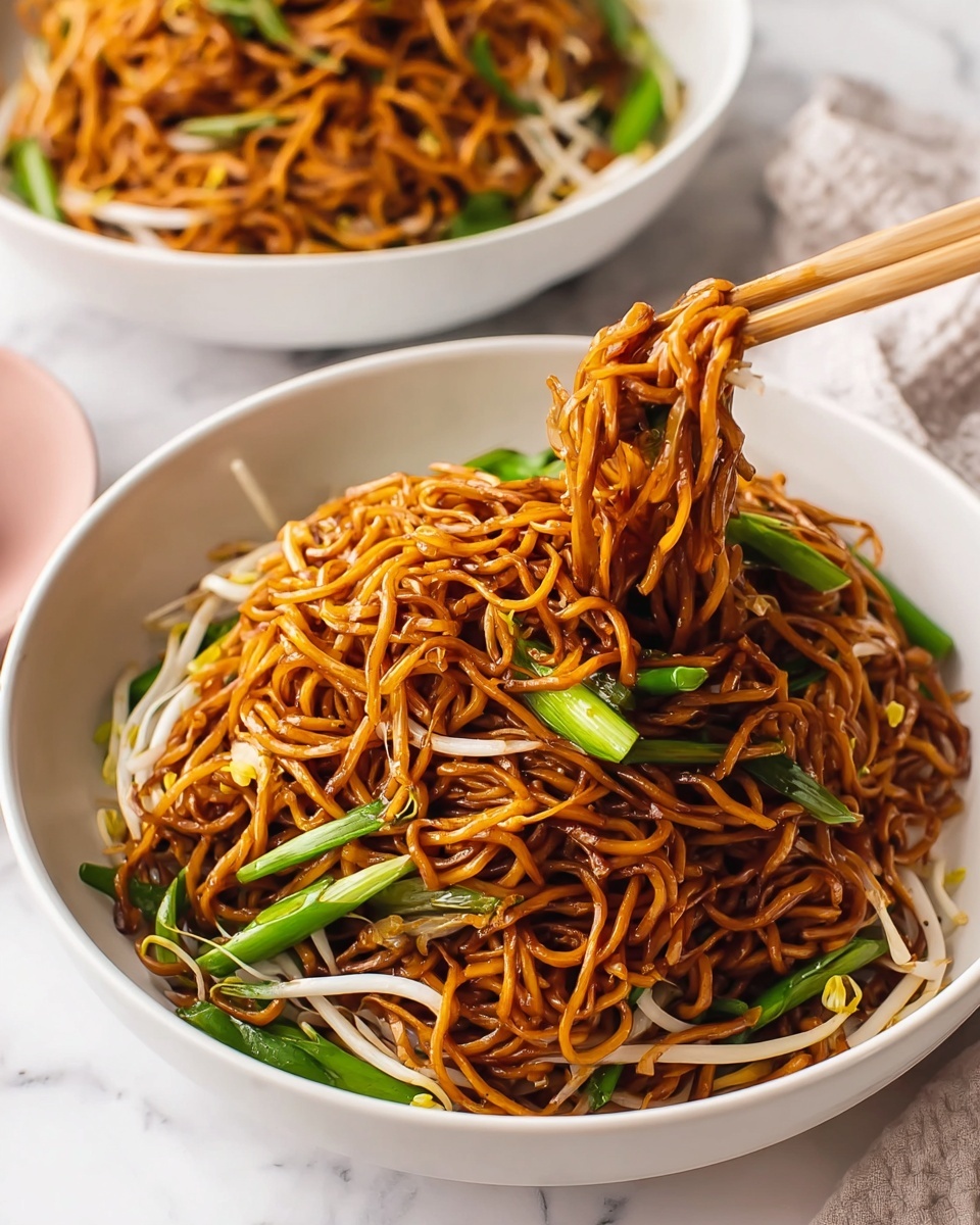 Single white bowl with a close-up of a single serving of stir-fried noodles tossed with bean sprouts and vibrant green scallions, showing glossy, slightly caramelized strands of noodles intertwined with fresh vegetables, highlighting the texture and slight sheen from the sauce, garnished with a few tender green onion pieces on top, placed on a white marble surface with natural lighting, intimate plated serving photo taken with an iphone --ar 4:5 --v 7