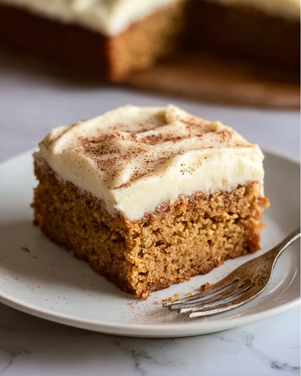 Kim's Buttermilk Spice Cake Recipe 6 A large white rectangular baking dish filled with an entire freshly baked carrot cake topped with smooth, thick layers of creamy white frosting sprinkled lightly with cinnamon, showcasing the full uncut cake with moist texture and evenly spread frosting, set on a white marble countertop with natural lighting, styled as a professional hero shot from a food magazine, photo taken with an iphone --ar 4:5 --v 7
