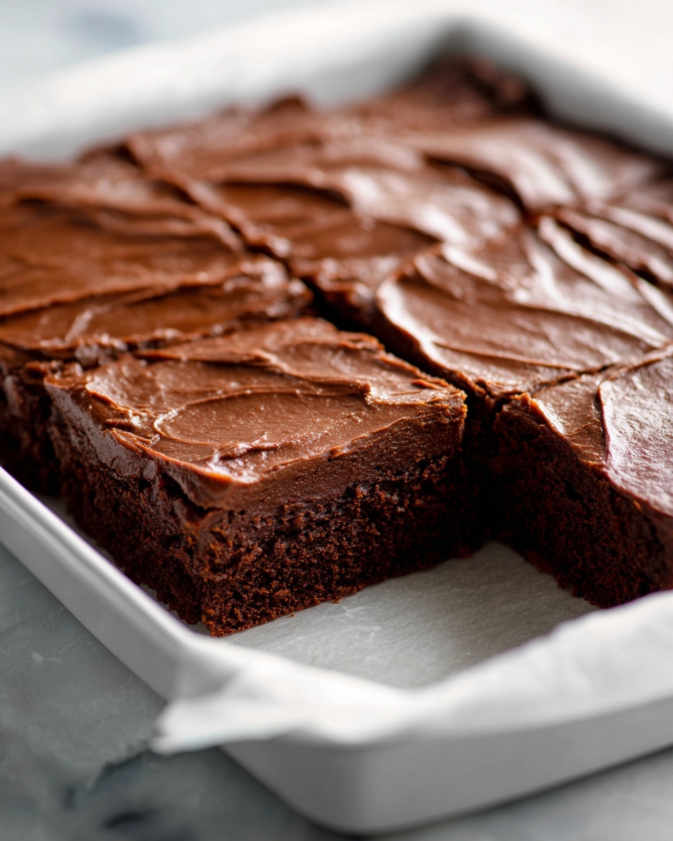 A large white rectangular baking pan filled with a whole batch of dense, rich chocolate brownies topped with a smooth, even layer of glossy chocolate frosting, the brownies perfectly set and uncut, showcasing their thick, fudgy texture throughout, photographed from a 3/4 angle on a white marble countertop, bathed in natural light, styled as a professional hero food shot from a magazine, photo taken with an iphone --ar 4:5 --v 7