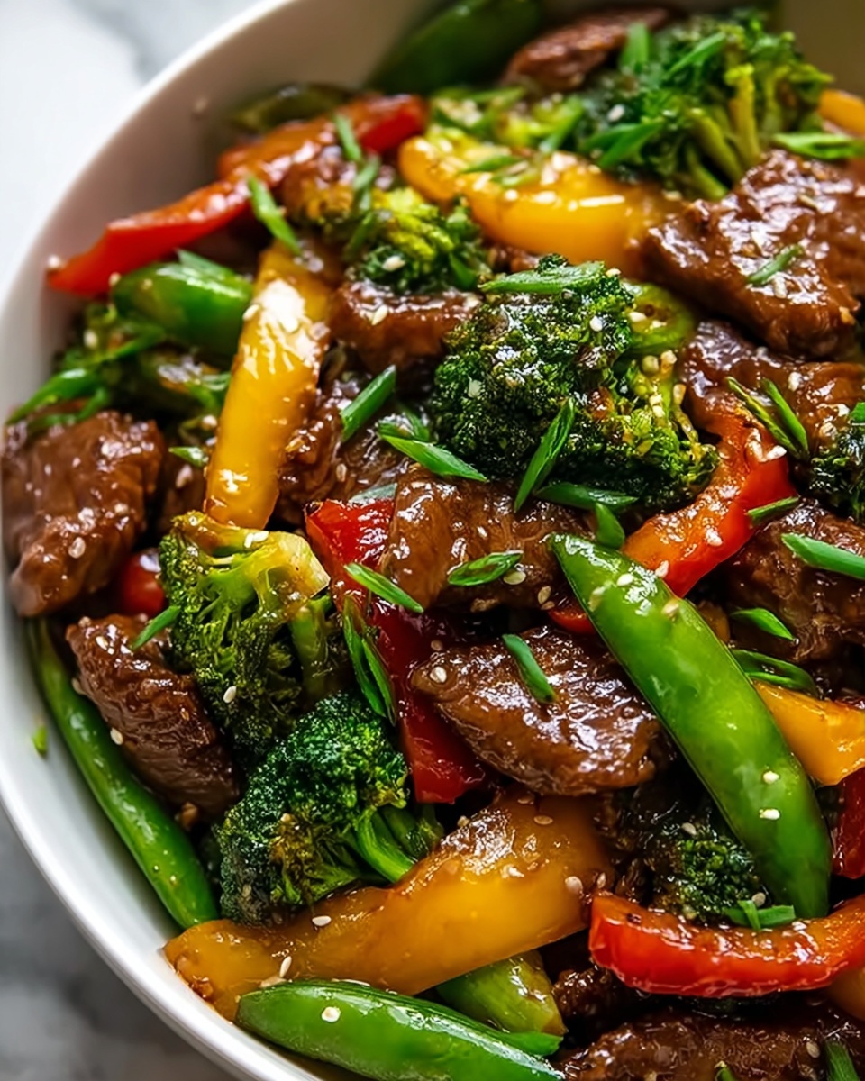 Large white serving bowl filled with vibrant beef stir-fry featuring glossy broccoli florets, bright orange carrot slices, crisp snap peas, and tender pieces of marinated beef, all tossed together with a light savory sauce and sprinkled with fresh chopped chives, presented as a full dish from a 3/4 angle on a white marble countertop with natural lighting, professional food styling photo taken with an iphone --ar 4:5 --v 7