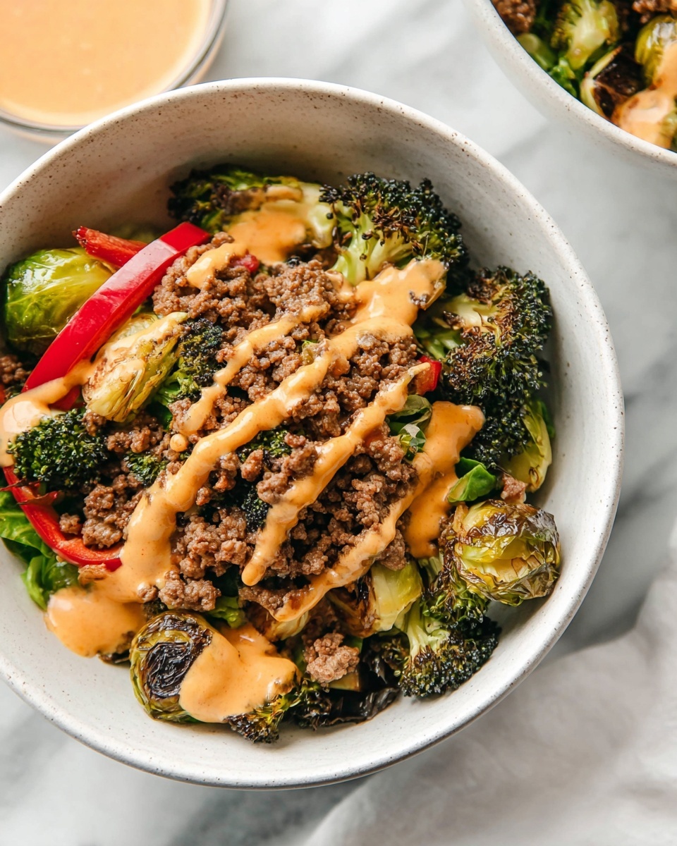 Two large white bowls filled with a colorful roasted vegetable and ground beef medley, featuring vibrant green broccoli florets, caramelized Brussels sprouts, and juicy red bell pepper pieces, generously drizzled with a creamy orange-hued sauce, all beautifully arranged and photographed from a 3/4 angle on a white marble countertop with natural lighting, professional food styling photo taken with an iphone --ar 4:5 --v 7