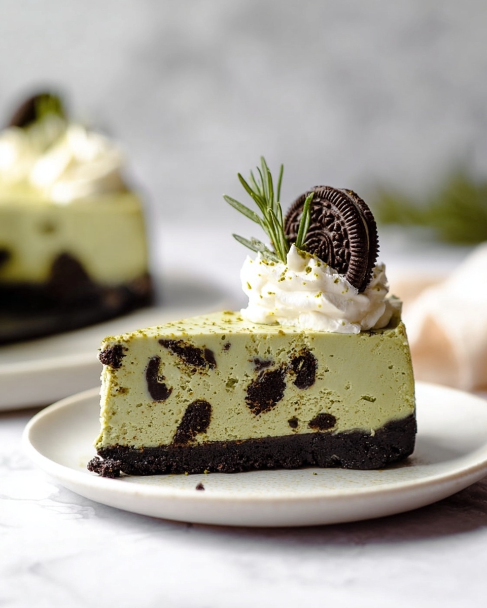 Whole round Oreo cheesecake with a thick, crumbly dark chocolate Oreo crust topped with smooth, pale green matcha cream layer decorated with evenly spaced dollops of whipped cream, each crowned by a mini Oreo cookie and a small sprig of fresh rosemary, presented on a white round cake board against a white marble background, captured from a professional 3/4 angle with natural lighting, showcasing the entire cake in a hero shot style photo taken with an iphone --ar 4:5 --v 7