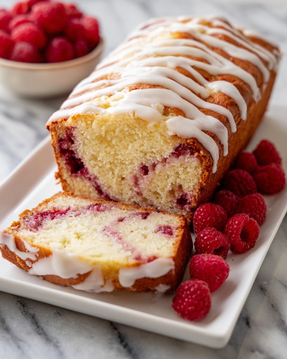 Whole loaf of raspberry swirl pound cake on a white rectangular platter, showcasing the entire uncut cake with smooth white icing drizzled over the top edges, the swirl pattern visible through the translucent glaze, garnished with fresh raspberries artfully arranged next to the cake, photographed from a 3/4 angle with natural lighting on a white marble background, professional food styling photo taken with an iphone --ar 4:5 --v 7